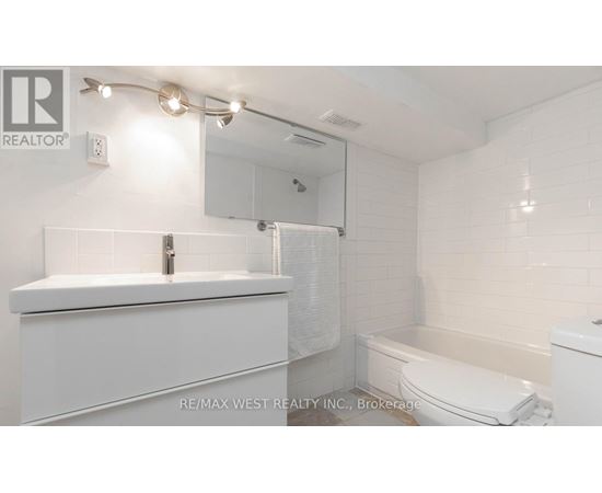 A white bathroom with a sink, toilet, and bathtub.