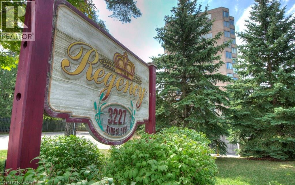 A sign for Regency 222 is displayed in front of a building and trees.