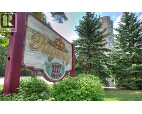 A sign for Regency 222 is displayed in front of a building and trees.