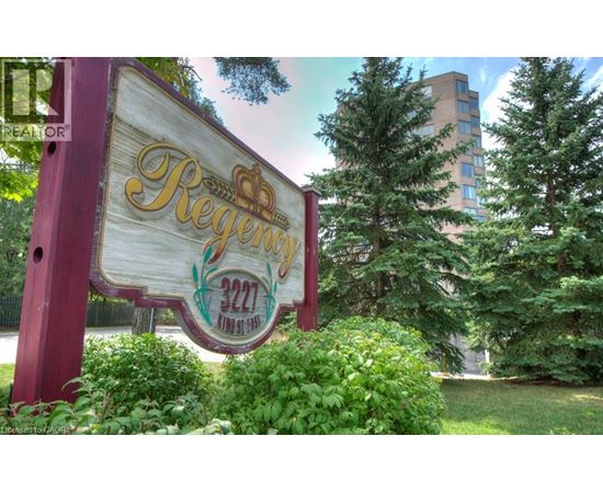 A sign for Regency 222 is displayed in front of a building and trees.