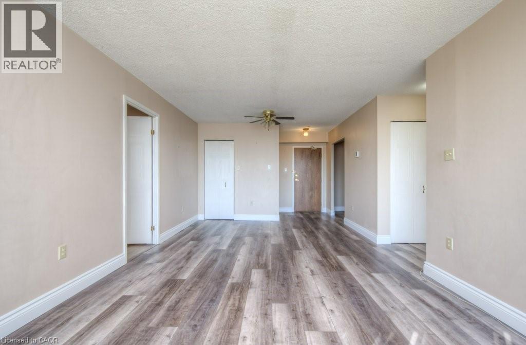 A spacious room with wood flooring and a ceiling fan.