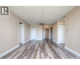 A spacious room with wood flooring and a ceiling fan.