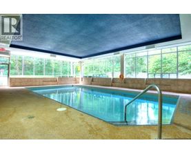 A pool inside a building with a REALTOR sign.