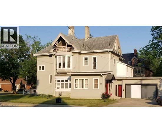A large house with a grey roof and a red door.