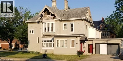 A large house with a grey roof and a red door.