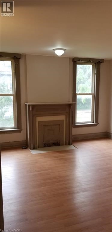 A room with a fireplace and wooden floors.