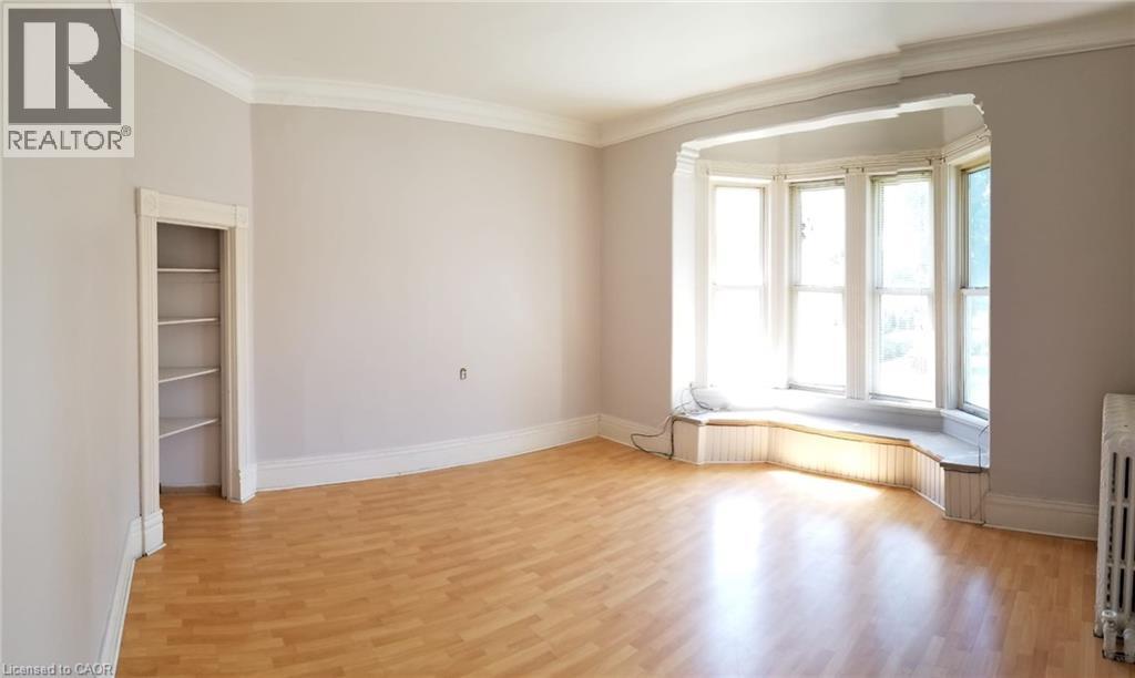 A room with wooden floors and a window with sunlight coming through.