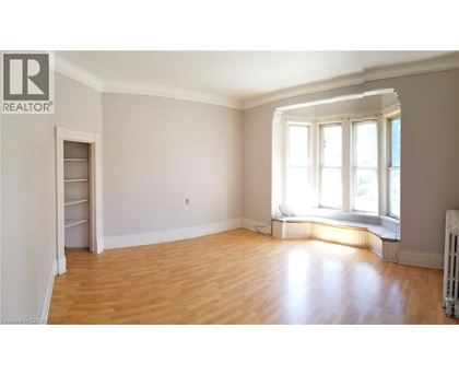A room with wooden floors and a window with sunlight coming through.