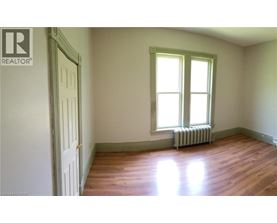 A room with a window and a radiator on the floor.