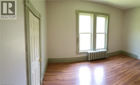 A room with a window and a radiator on the floor.