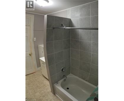 A bathroom with a tiled shower and a white toilet.