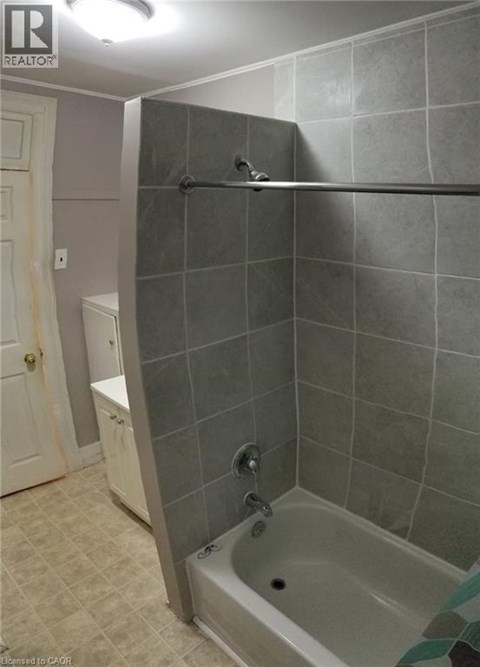 A bathroom with a tiled shower and a white toilet.
