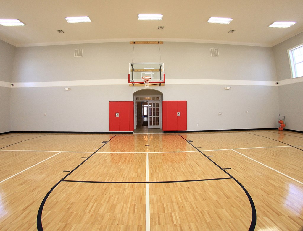 a large gym with a basketball court and a basketball hoop