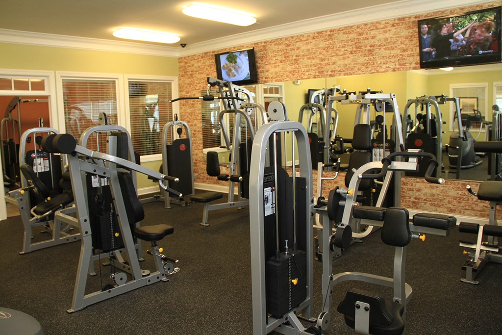 a gym with a variety of exercise equipment and a tv