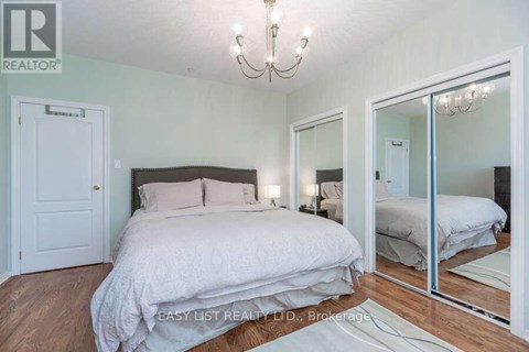 A bedroom with a large bed and a chandelier.