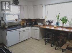 A kitchen with white cabinets and a wooden island.