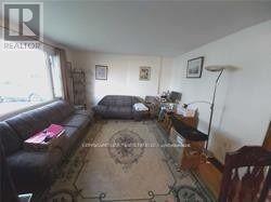 A living room with a couch, a chair, and a rug.