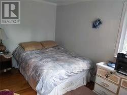 A bedroom with a bed, nightstand, and lamp.
