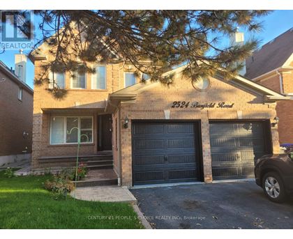 A house with a garage and a car parked in front.