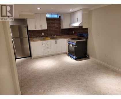 A kitchen with white cabinets and a brick backsplash is shown.