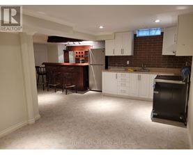 A kitchen with white cabinets and a brick wall.