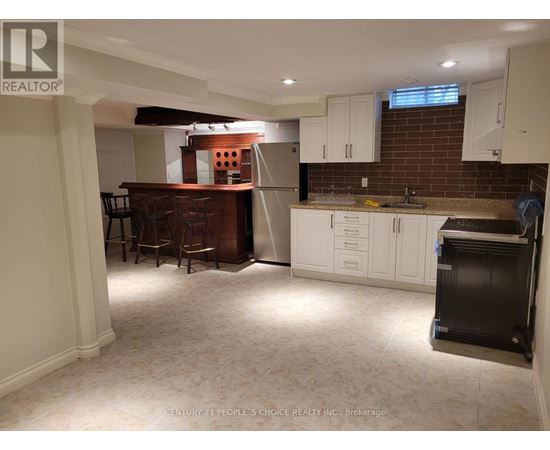 A kitchen with white cabinets and a brick wall.