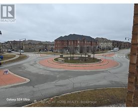 A view of a roundabout in a residential area with a sign for Right at Home Realty, Brokerage.