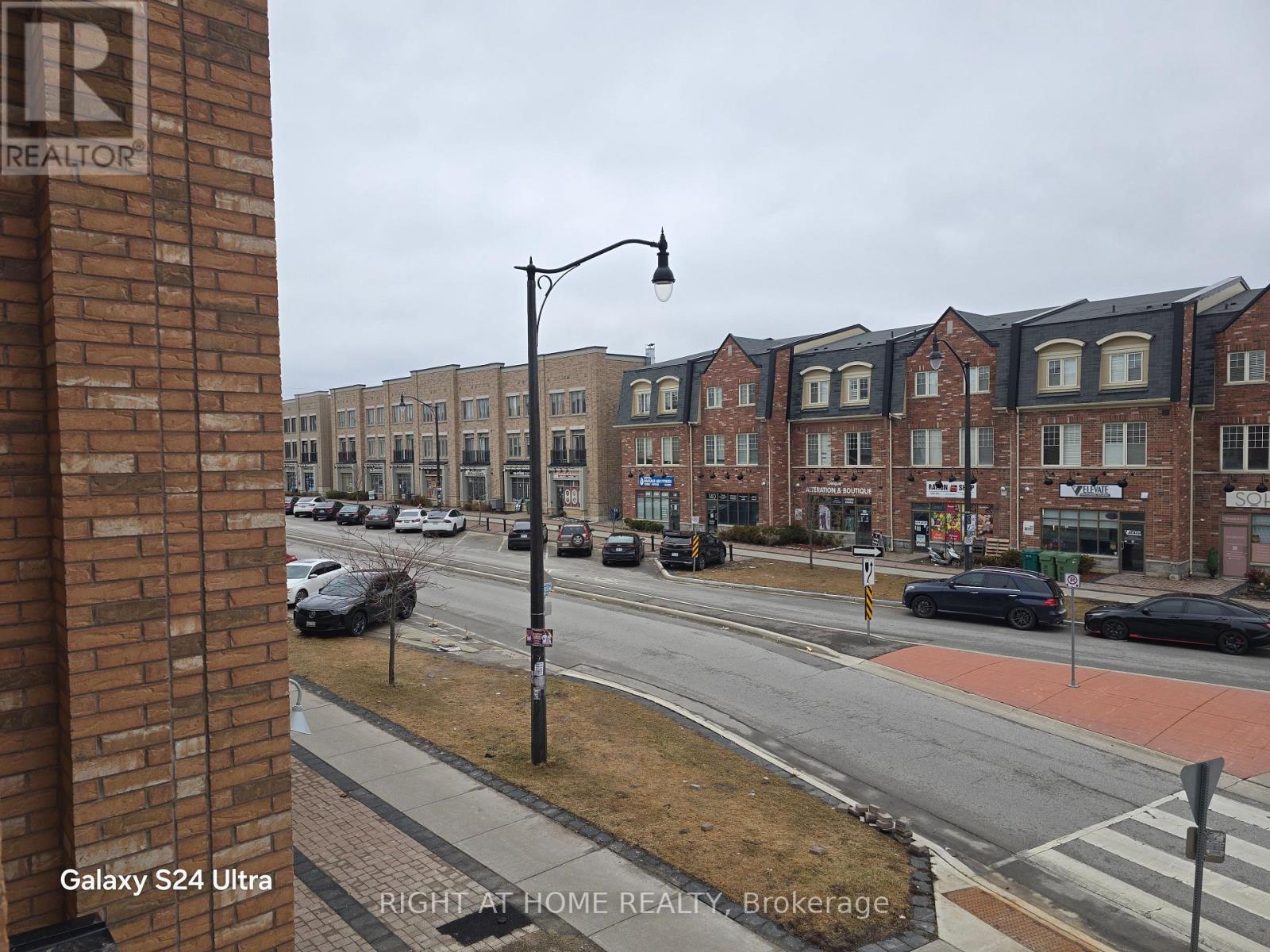 A view of a street from a window with a sign that says REALTOR.
