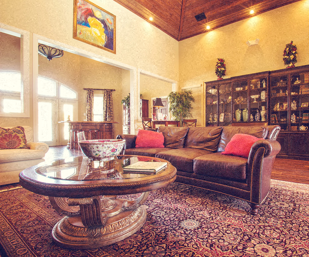 A living room with a brown couch and a glass coffee table.