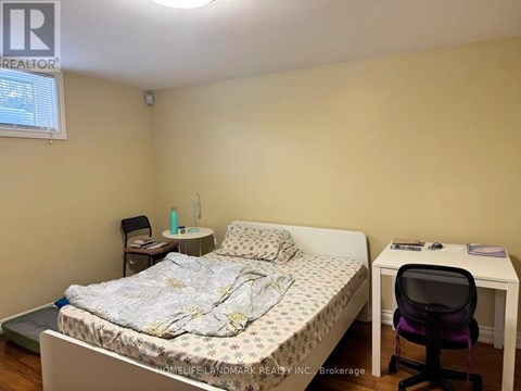 A bedroom with a bed, desk, and chair.