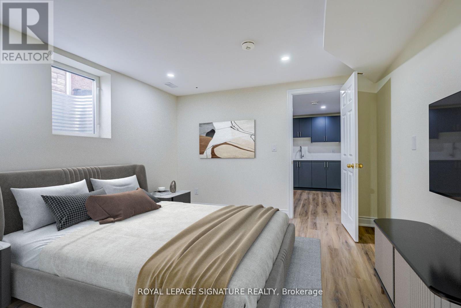 A bedroom with a large bed and a painting on the wall.
