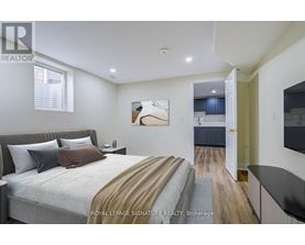 A bedroom with a large bed and a painting on the wall.