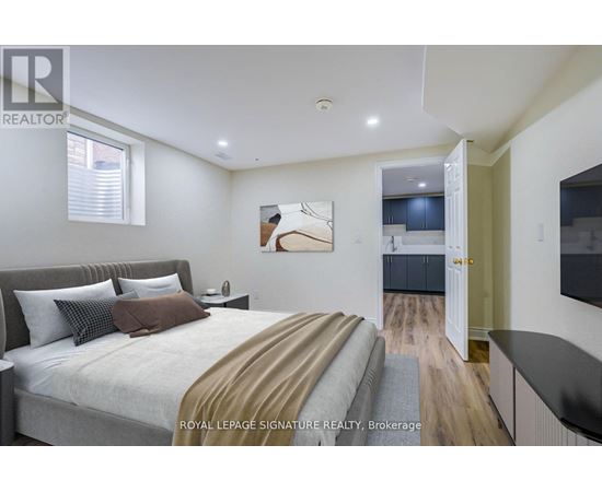 A bedroom with a large bed and a painting on the wall.