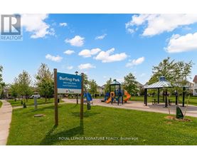 A sign for Burlington Bay Park is in front of a playground.