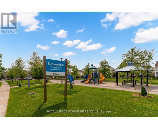 A sign for Burlington Bay Park is in front of a playground.