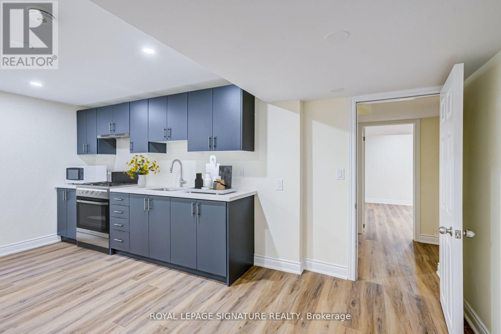 A kitchen with wooden floors and a white ceiling.