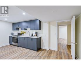 A kitchen with wooden floors and a white ceiling.