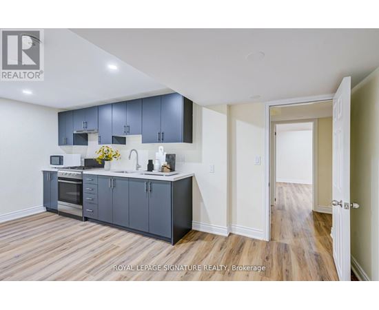 A kitchen with wooden floors and a white ceiling.