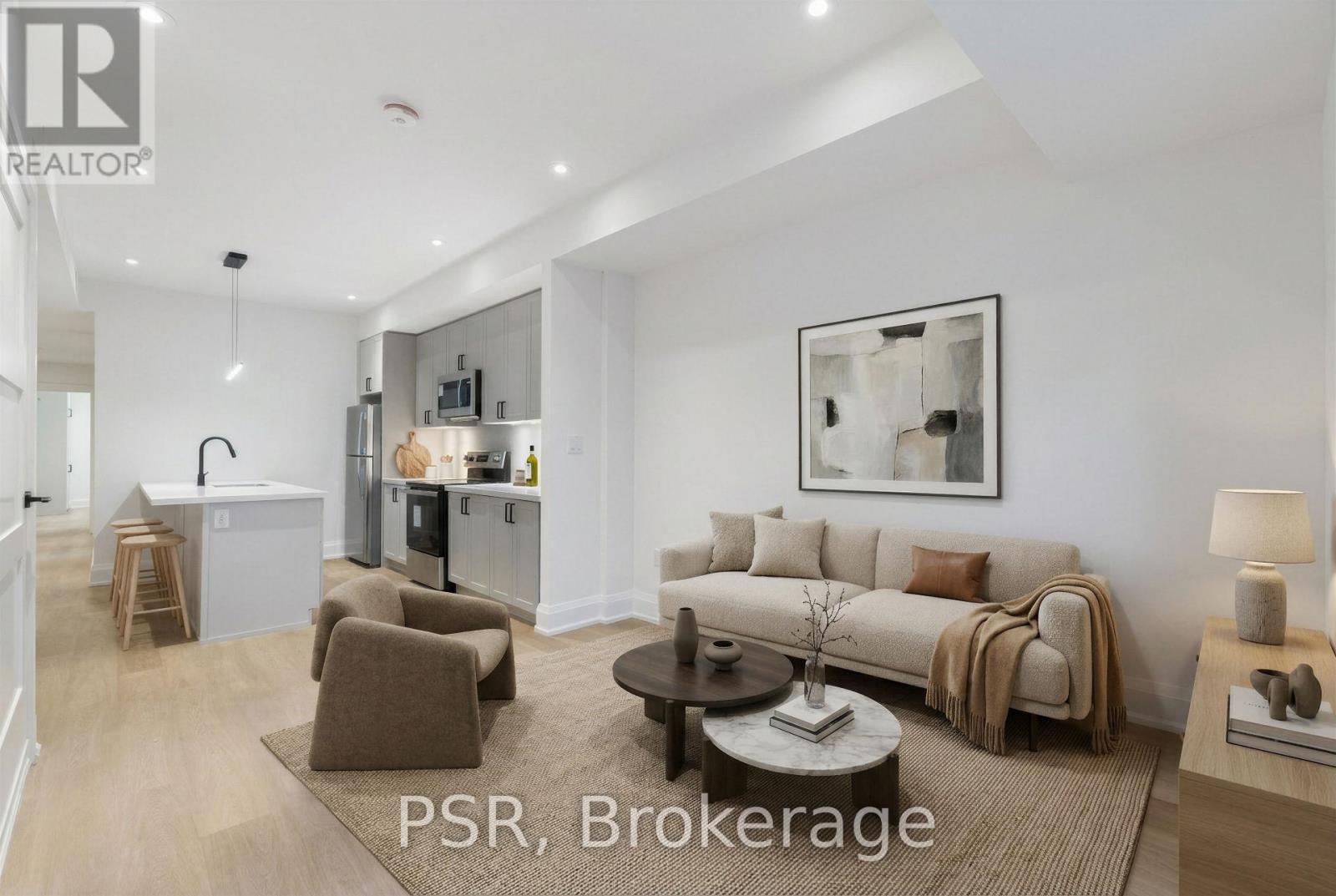 A well-lit living room with a sofa, armchairs, and a coffee table.
