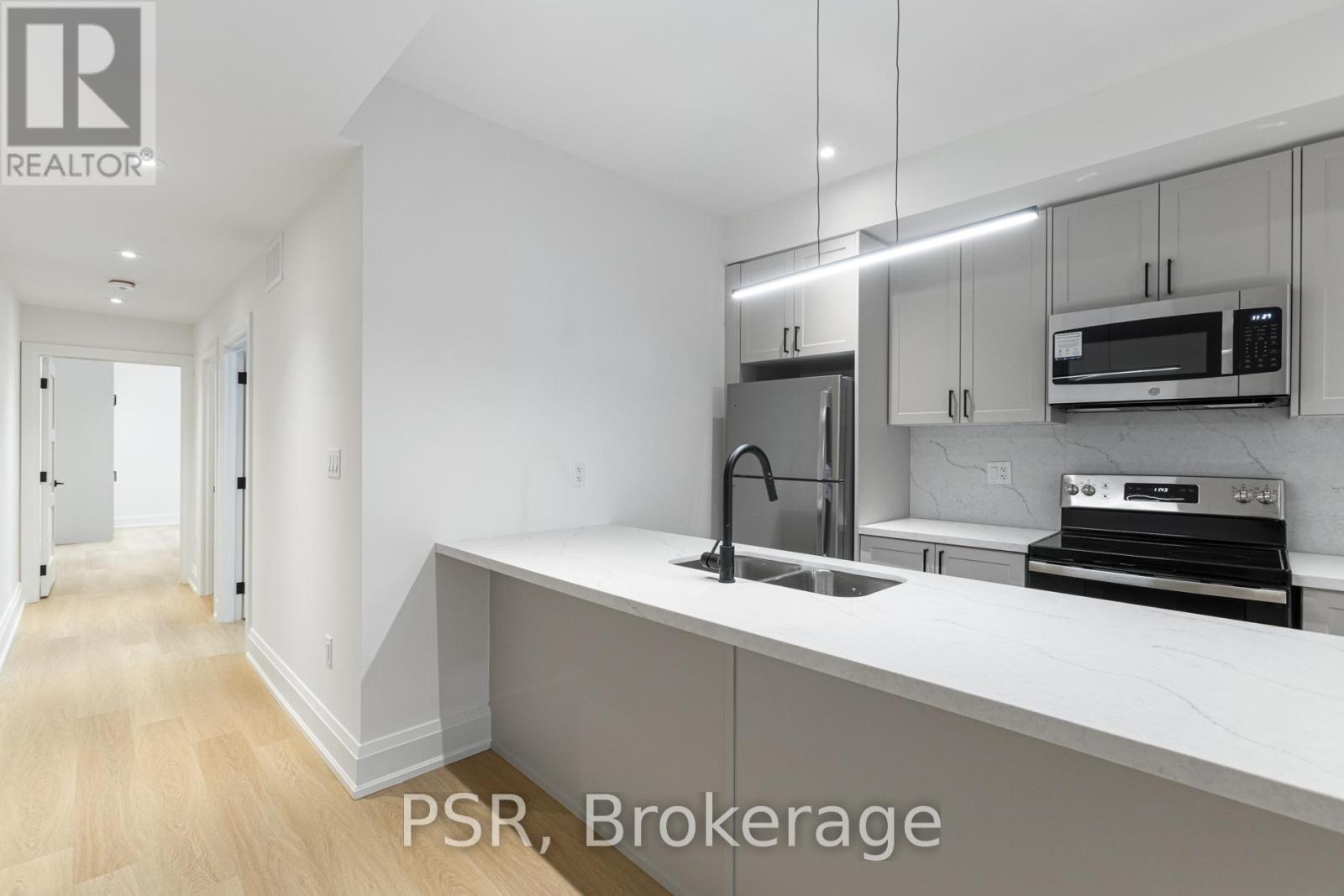 A kitchen with white cabinets and appliances is on the market.
