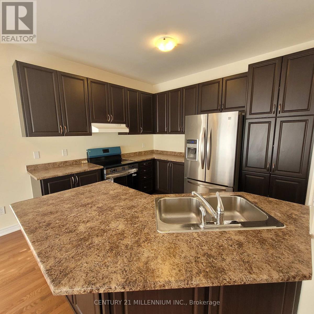 A kitchen with granite countertops and dark brown cabinets.