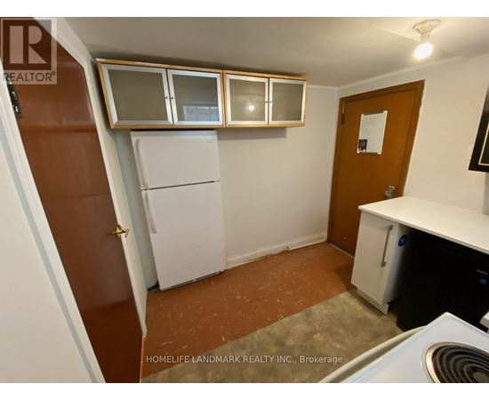 A small kitchen with a refrigerator, cabinets, and a stove top oven.
