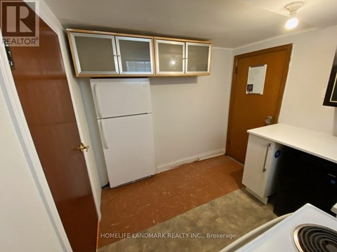 A small kitchen with a refrigerator, cabinets, and a stove top oven.