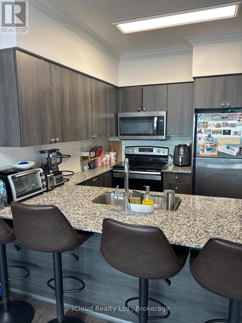 A kitchen with brown chairs and a granite countertop.