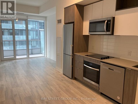 A kitchen with a refrigerator, oven, and microwave.