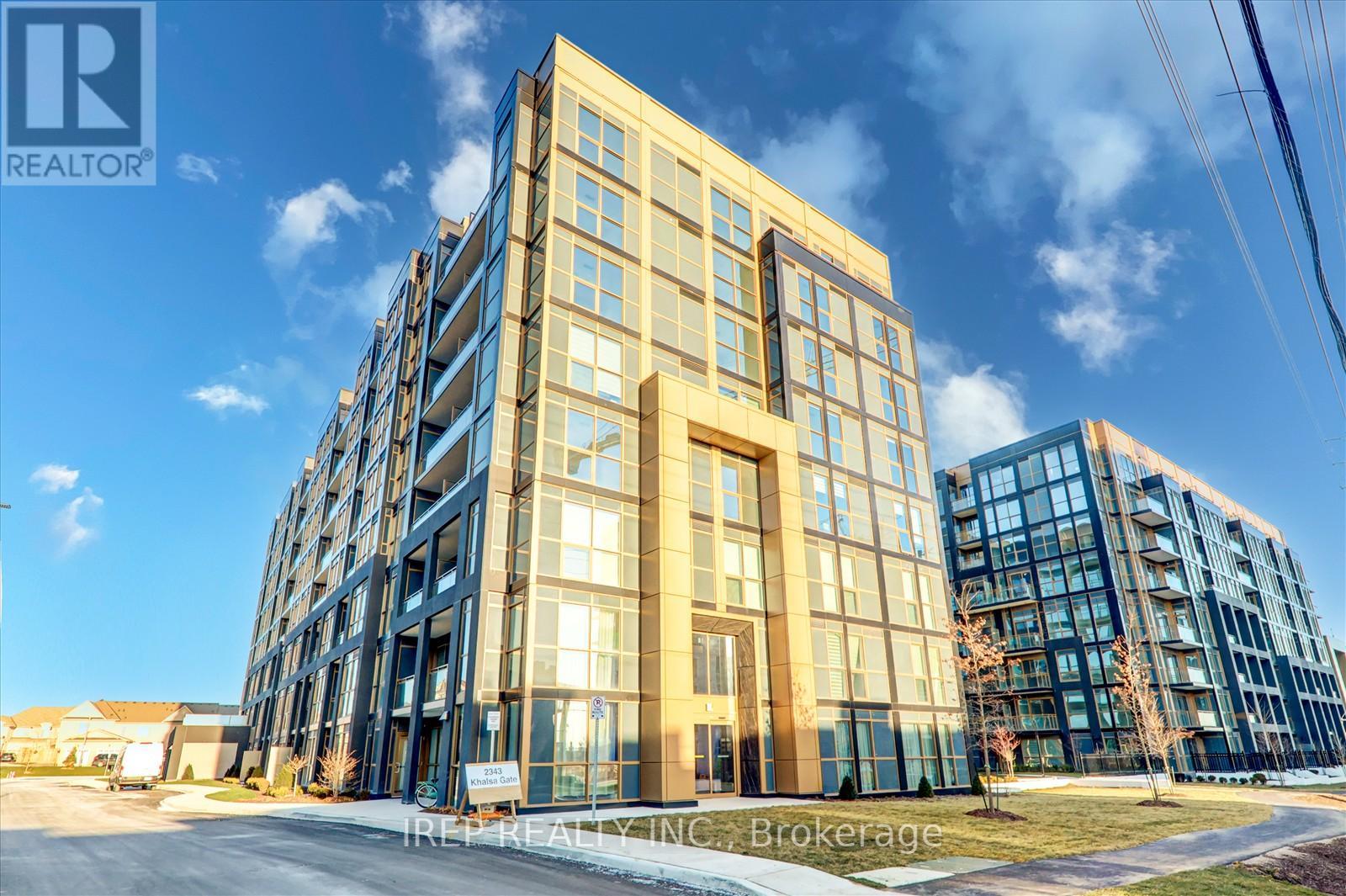 A modern multi-story building with a glass facade is under the REALTOR® Brokerage sign.