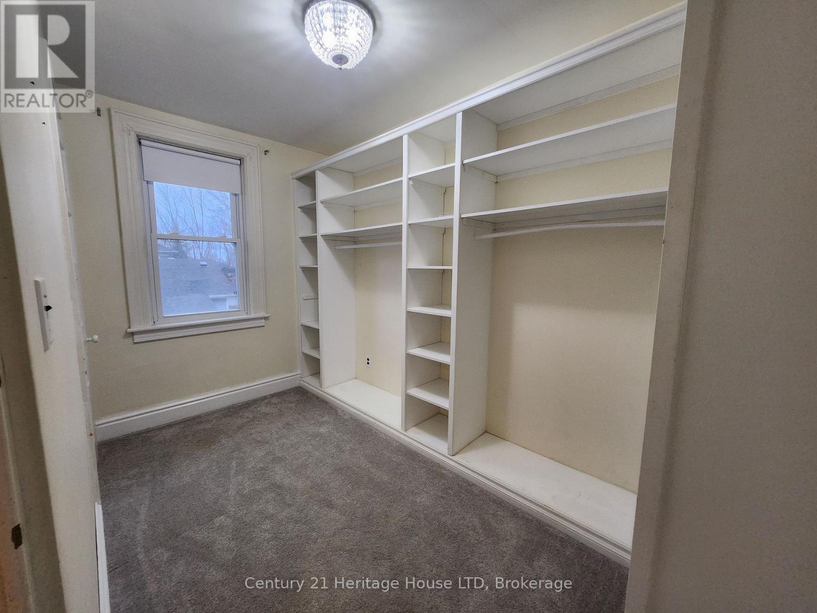 A bedroom with a window and built-in shelves.
