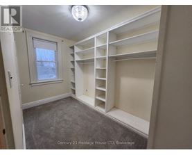 A bedroom with a window and built-in shelves.
