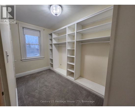 A bedroom with a window and built-in shelves.