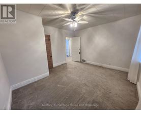 A spacious room with a ceiling fan and carpeted floor.